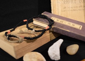 Antique ojuzu (Buddhist prayer beads) and sutra book, along with rocks from the Rohwer incarceration camp. Items lent by Mary Kamidoi.